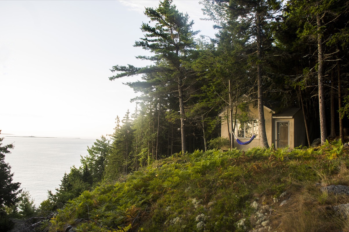 A sheltered porch with wicker seating looking out toward Frenchman Bay