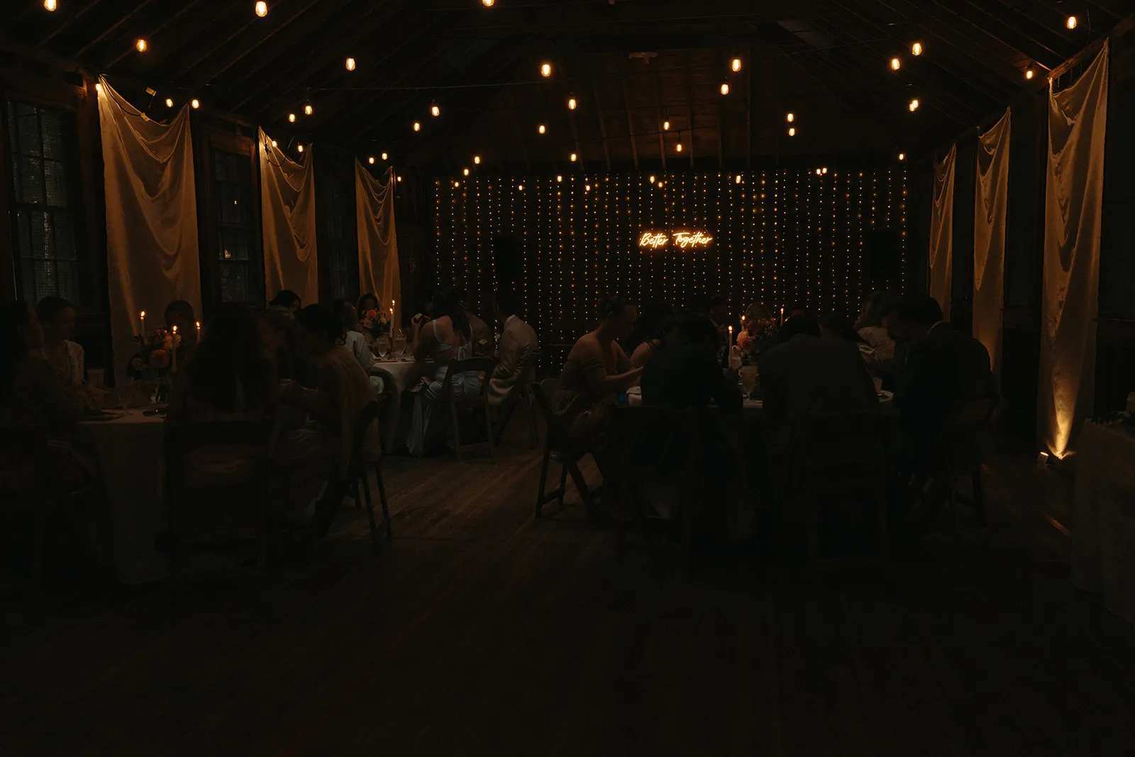 The Game House cleared for a wedding dinner, long tables under strings of lights