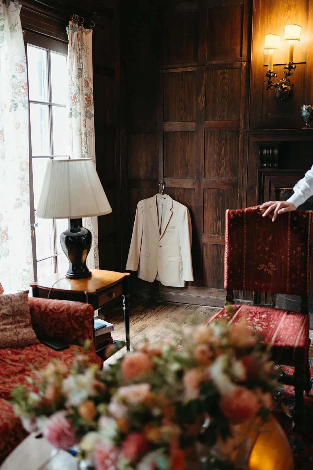 Morning in the living room: a suit hung by the window, a lamp and a bouquet on the sofa